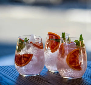 Three glasses of sparkling grapefruit and mint cocktails with ice.